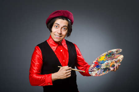 Funny artist in dark studioの写真素材