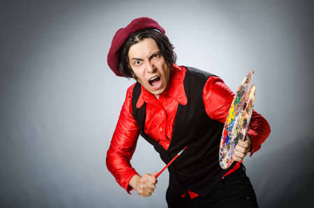 Funny artist in dark studioの写真素材