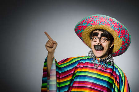 Man in vivid mexican poncho against gray