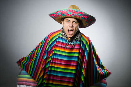 Man in vivid mexican poncho against grayの写真素材