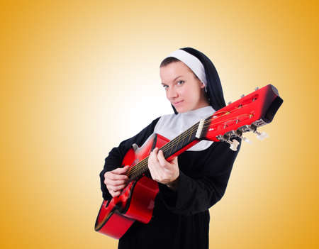 Nun playing guitar against the gradientの写真素材