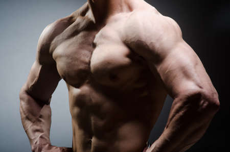 Muscular man posing in dark studioの写真素材