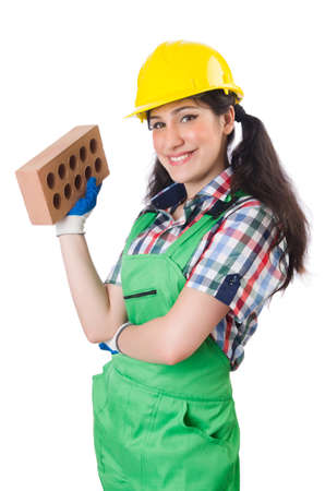 Female workman in green overalls holding brick isolated on whiteの写真素材