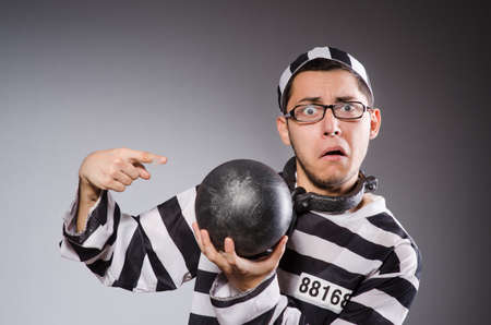 Young prisoner in chains against grayの写真素材