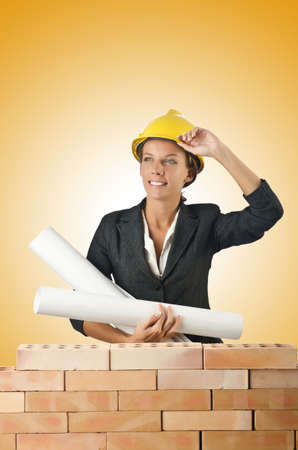 Businesswoman with drawings near brick wallの写真素材