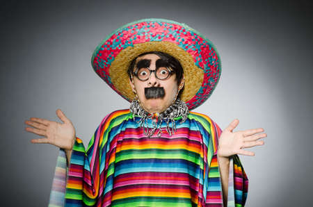Man in vivid mexican poncho against grayの写真素材