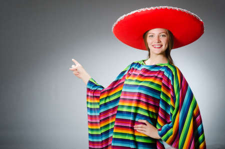 Girl in mexican vivid poncho against grayの写真素材