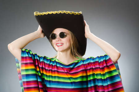 Girl in mexican vivid poncho against grayの写真素材