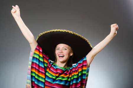 Girl in mexican vivid poncho against grayの写真素材
