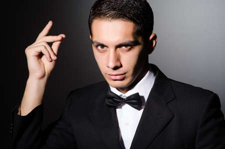 Young businessman in dark studioの写真素材
