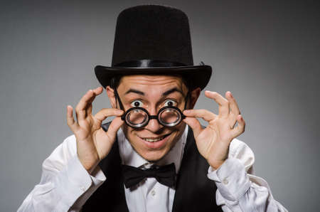 Young man in classical black vest and hat against grayの写真素材