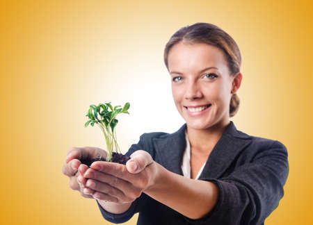 Businesswoman with seedling on whiteの写真素材