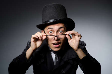 Young man in black coat and hat against grayの写真素材