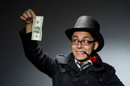 Young detective in black coat with money against grayの写真素材