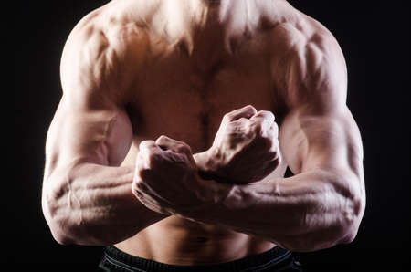 Muscular man posing in dark studioの写真素材