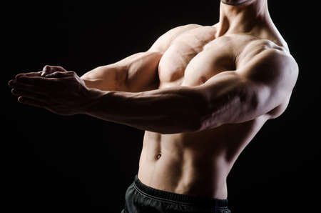 Muscular man posing in dark studioの写真素材