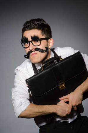 Young caucasian man with false moustache against grayの写真素材