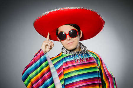 Man in vivid mexican poncho against grayの写真素材