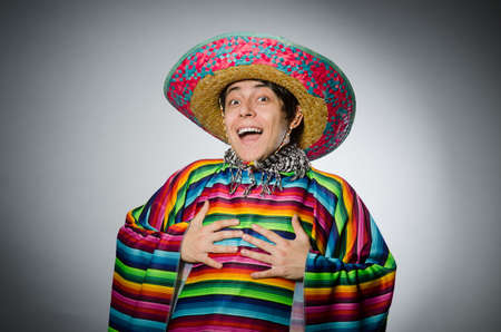 Man in vivid mexican poncho against grayの写真素材