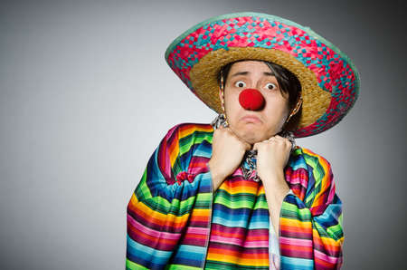 Man in vivid mexican poncho against grayの写真素材