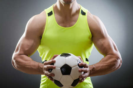 Muscular man with football ballの写真素材