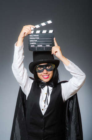 Woman wearing mask with movie boardの写真素材