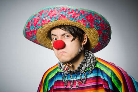 Man in vivid mexican poncho against grayの写真素材