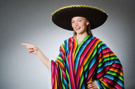 Girl in mexican vivid poncho against grayの写真素材