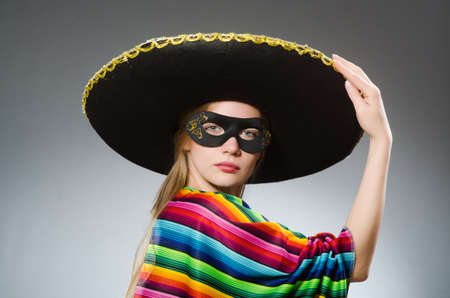 Girl in mexican vivid poncho against grayの写真素材