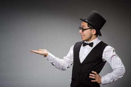 Young man in classical black vest and hat against grayの写真素材
