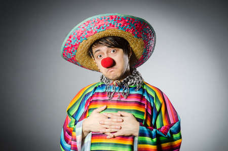Man in vivid mexican poncho against grayの写真素材