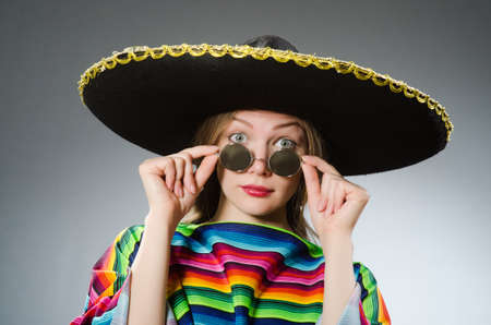 Girl in mexican vivid poncho against grayの写真素材