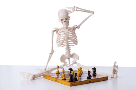 Skeleton playing chess game on whiteの写真素材