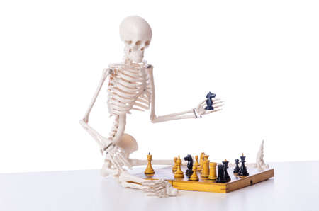Skeleton playing chess game on whiteの写真素材