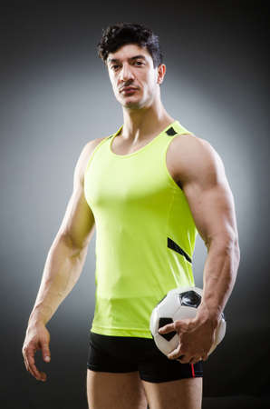 Muscular man with football ballの写真素材
