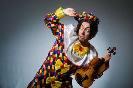 Funny violin clown player in musical conceptの写真素材