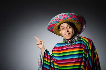 Man in vivid mexican poncho against grayの写真素材