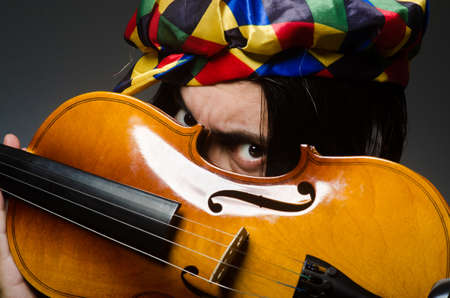 Funny violin clown player in musical conceptの写真素材