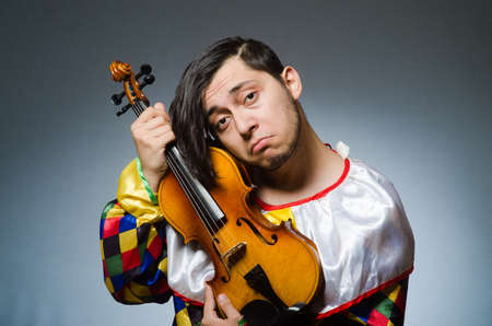 Funny violin clown player in musical conceptの写真素材
