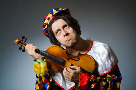 Funny violin clown player in musical concept