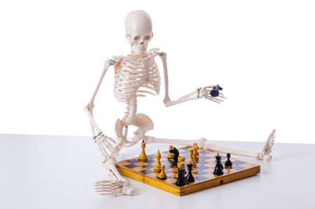 Skeleton playing chess game on whiteの写真素材