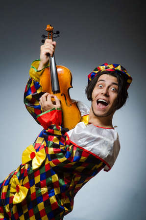Funny violin clown player in musical conceptの写真素材