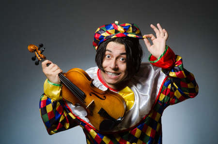 Funny violin clown player in musical concept