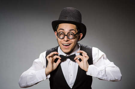 Young man in classical black vest and hat against grayの写真素材