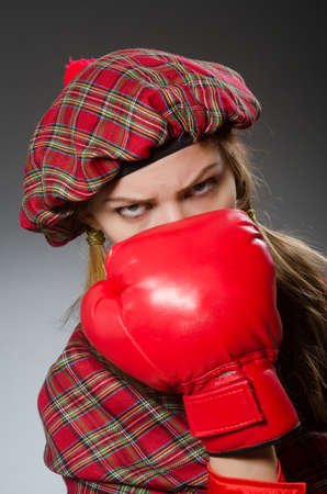 Woman in scottish clothing in boxing conceptの写真素材