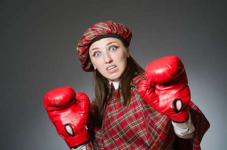 Woman in scottish clothing in boxing conceptの写真素材
