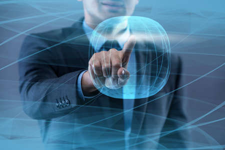 Businessman pressing virtual button in futuristic conceptの写真素材