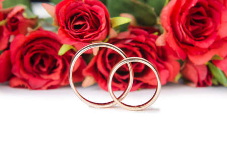 Wedding rings and flowers isolated on white backgroundの写真素材