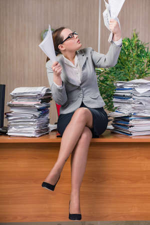 Businesswoman under stress working in the officeの写真素材