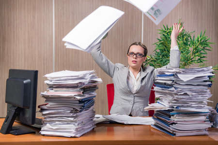 Businesswoman under stress working in the officeの写真素材